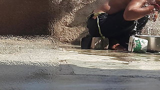 Indian sister-in-law is bathing in the open courtyard of the house, putting a finger in her burrow and rubbing the body, sister-in-law is washing the bathroom.