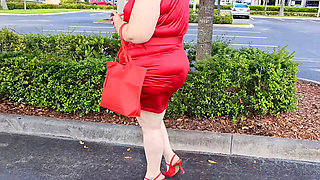 Beautiful woman walking outdoors in public parking lot showing off for strangers