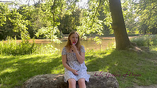 Innocent Girl Sits in the Park and Eats Lollipop Not Knowing That Her Panties Can Be Seen